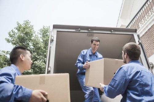 A moving team handling boxes and furniture in Colliers Wood